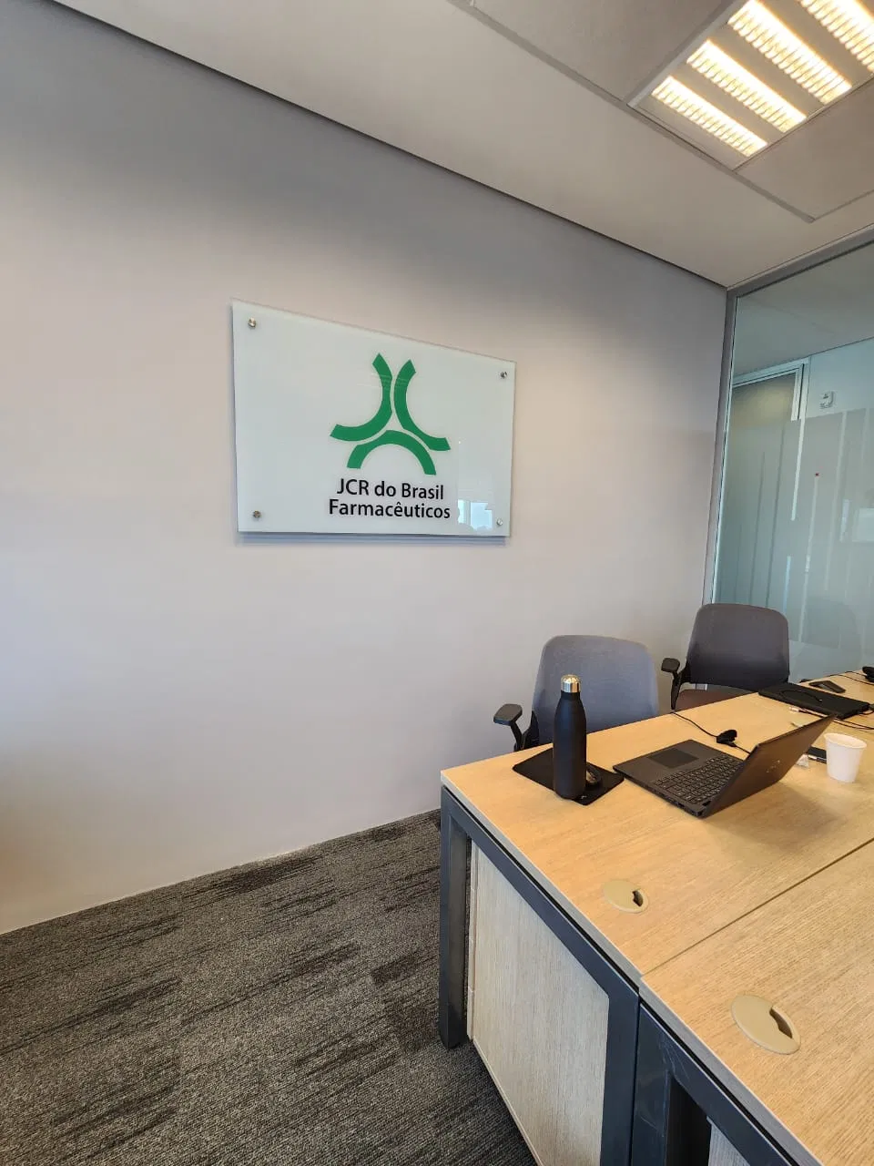 Targhetta in vetro Jcr Farmaceuticos con logo verde
